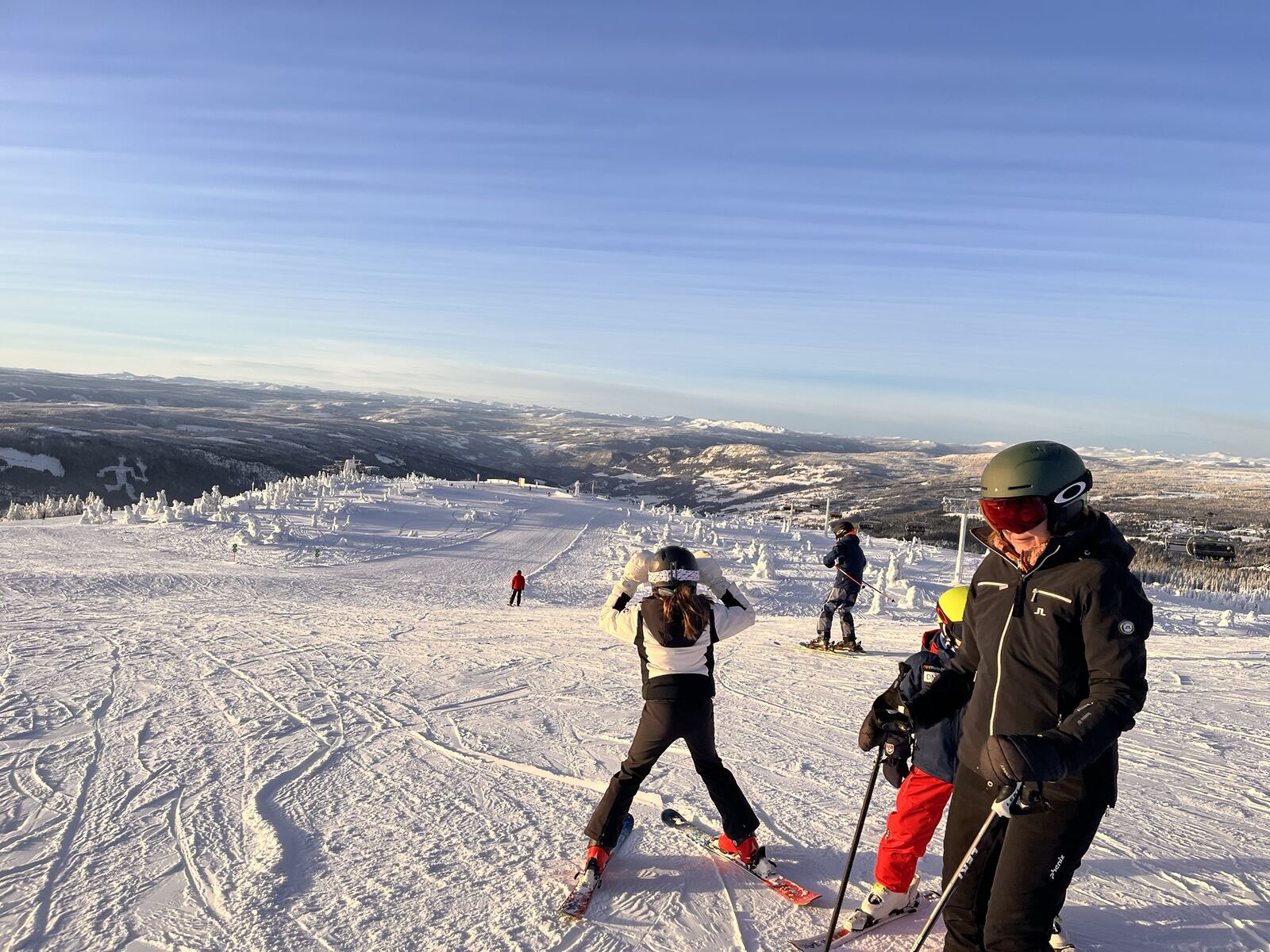 Familie samlet på toppen av bakken en klar vinterdag