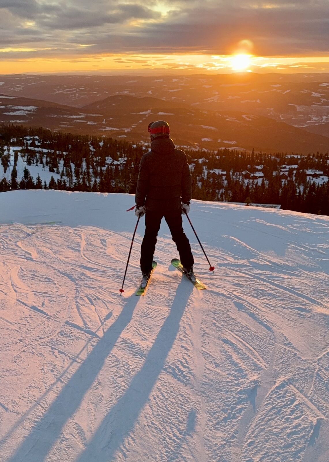 Skiløper i solnedgang på toppen av Hafjell