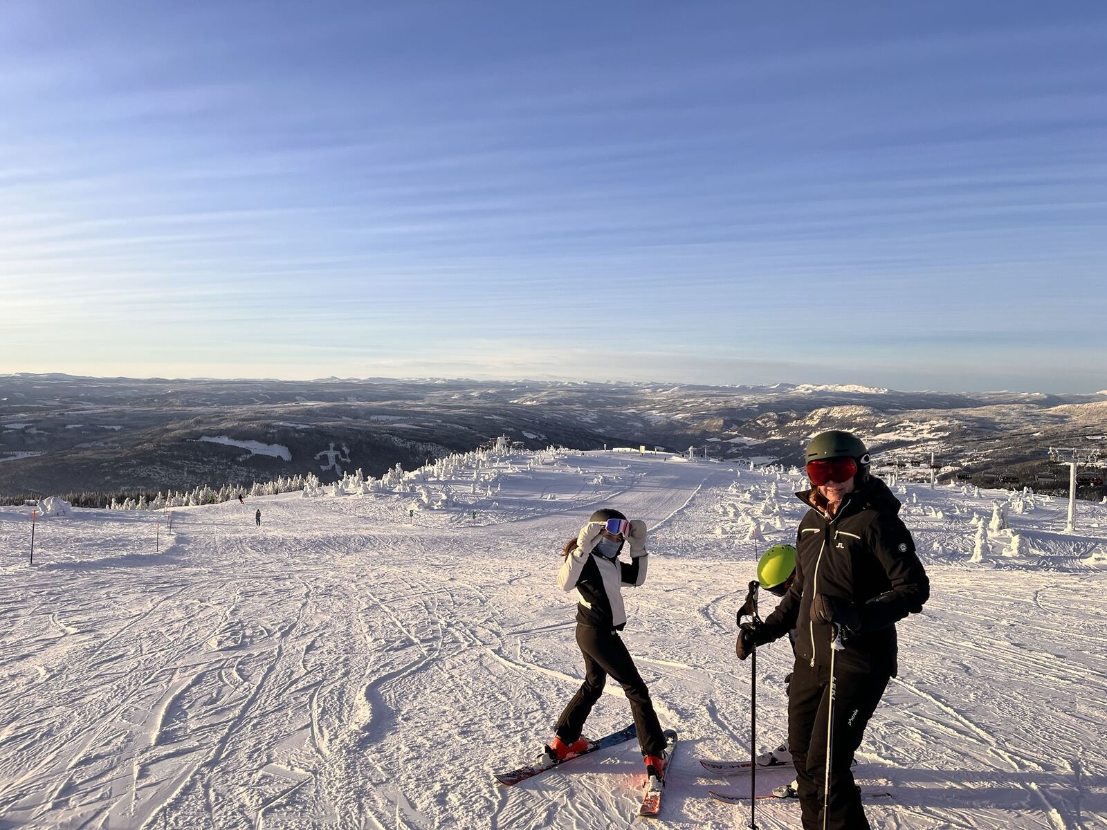 Familie på ski på toppen av Hafjell med utsikt over dalen